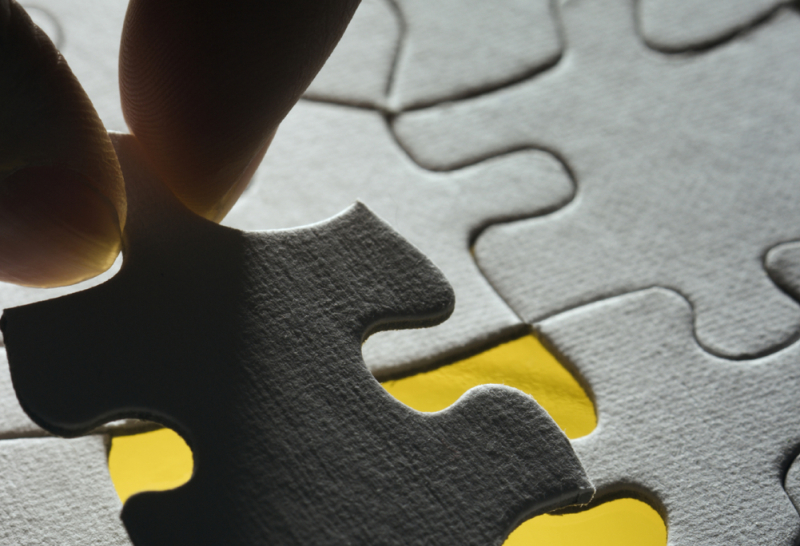 Pièce de puzzle en main