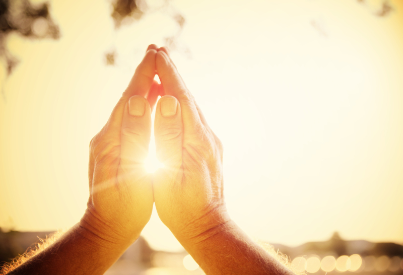Mains jointes sous un soleil